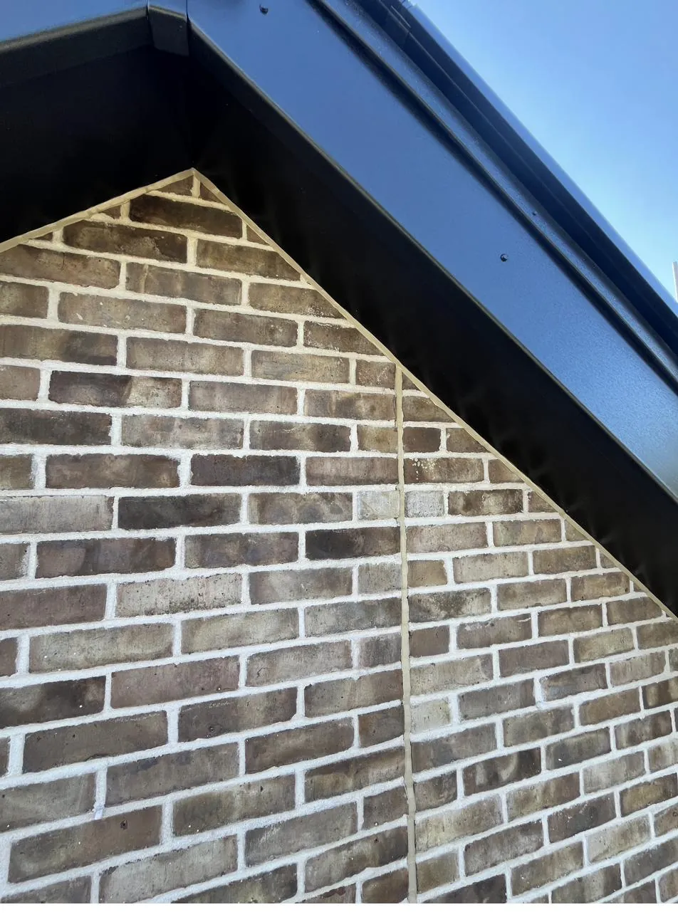 Brick apex after exterior mastic applied along the roofline
