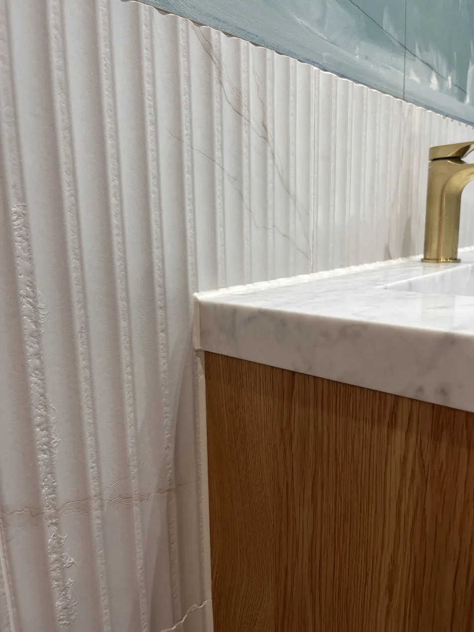 Fluted tile splashback after sealant, flush clean line against marble countertop