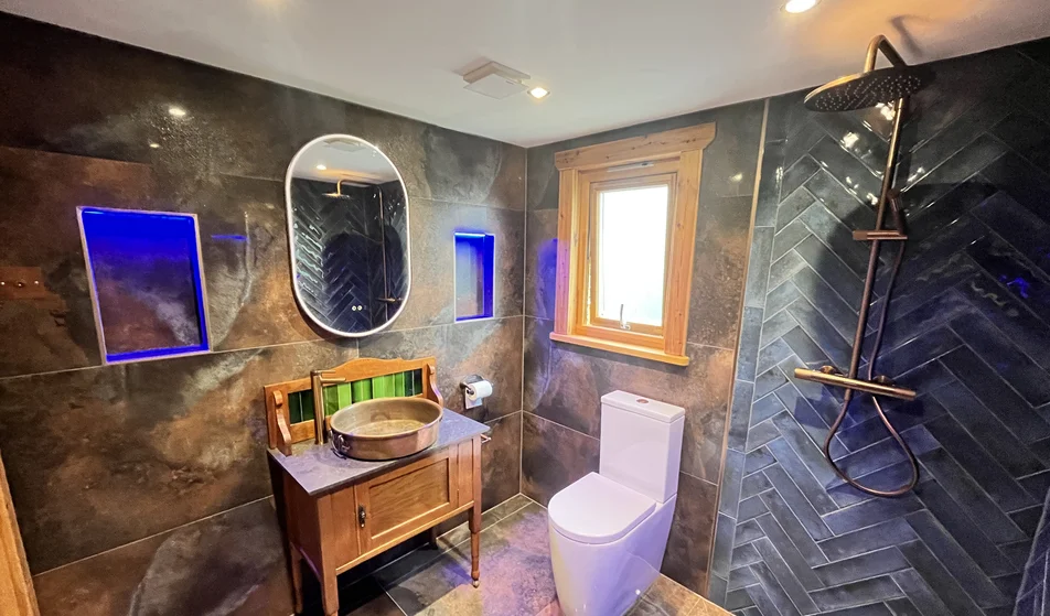Finished bathroom with herringbone tiled shower, sealed vanity and window joints