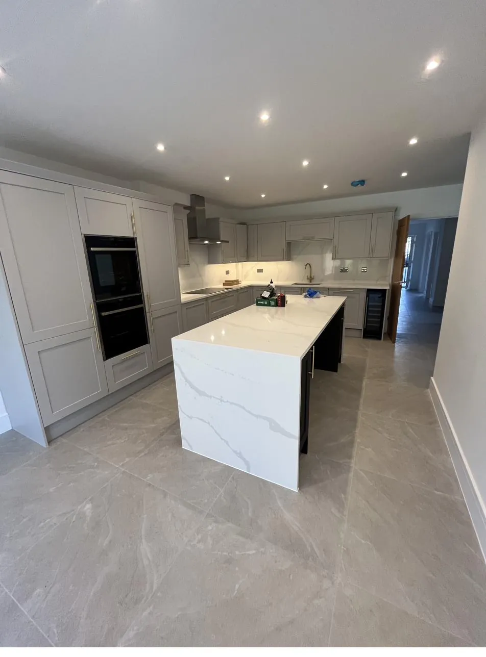 Open-plan kitchen with quartz island, sealant along worktop joints