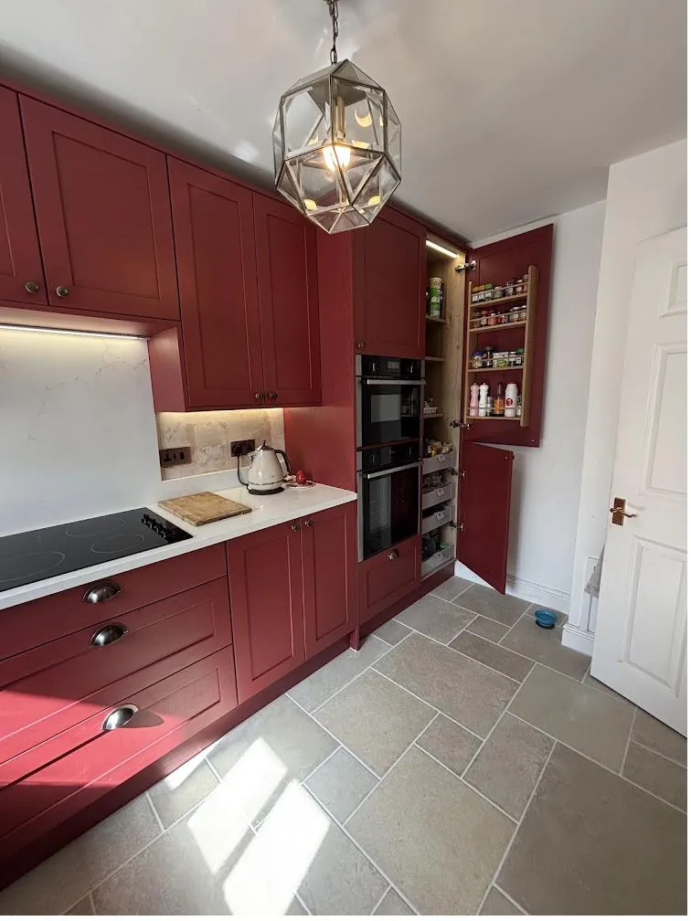 Red shaker kitchen with worktop and upstand sealed neatly around the hob