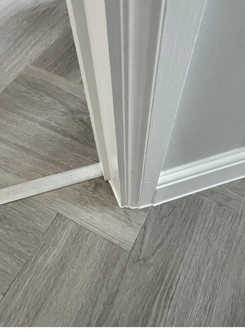 Close-up of a clean skirting-to-floor sealant line